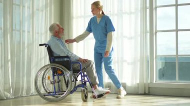 Emeklilik sağlık hizmetlerine destek ol. Hemşire tekerlekli sandalyedeki yaşlı adama yardım ediyor. Hasta ve kadın tıbbi bakım için huzurevinde. Engelli insanlar için tekerlekli sandalyede felçli bir adama bakan hemşire.