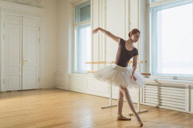Bale dersinde etekli balerin dans ederek bale yapıyor. Dans stüdyosundaki genç klasik dansçı kadın. Bale sınıfı eğitimi. Bale okulu konsepti