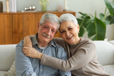Yetişkin bir çiftin evde kucaklaşması. Orta yaşlı karı ve koca şefkatle kucaklaşıp tatlı bir bağ kurmanın tadını çıkarıyorlar. Büyükannem ve büyükbabam birlikte. Aile zamanı sevgi ve ilgi