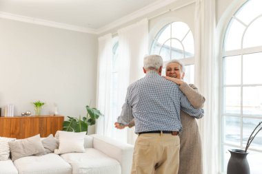 Yürümeye devam. Romantik olgun çift evde müzik eşliğinde dans ediyor. Mutlu gülümseyen aile emeklisi kadın koca eş birlikte eğleniyor. Aile zamanı aşk bakımı