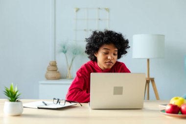 African american girl using laptop at home office looking at screen typing chatting reading writing email. Young woman having virtual meeting online chat video call conference. Work learning from home