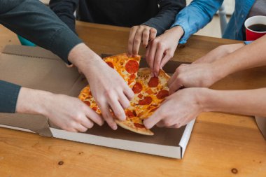 Ev partisi. Üst düzey erkek eller, pizza kutusundan pizza dilimleri alıyor. Bir grup aç arkadaş lezzetli öğle yemeklerini paylaşıyor ve pepperonili pizza sipariş ediyorlar. Pizza siparişi.