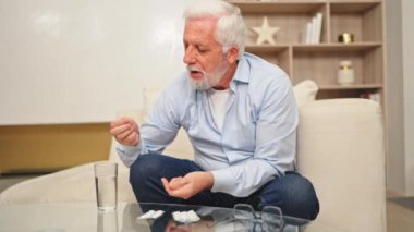 Medikal hapı ve bir bardak suyla orta yaşlı bir adam. Olgun yaşlı büyükbaba ilaç tedavisi hapları alıyor vitamin. Yaş reçeteli ilaç sağlık tedavisi kavramı