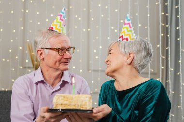 Bir dilek tut. Parti şapkalı son sınıf aile çifti evde birlikte doğum günü kutluyor. Yaşlı kadın doğum günü pastasında yanan mumları üflüyor. Yaşlı adam karısına mutlu yıllar diliyor.
