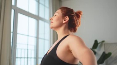 Fitness antrenmanı. Dambılları kaldıran kadın. Artı ev içinde spor egzersizi yapan beden bir kadın. Spor giyimli kız kilo vermek için ağırlık çalışması yapıyor. Spor ve zindelik