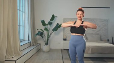Fitness antrenmanı. Evde spor yapan bir kadın. Artı ev içinde spor egzersizi yapan beden bir kadın. Spor giyimli kız kilo vermek için ağırlık çalışması yapıyor. Spor ve zindelik