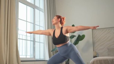Yoga fitness antrenmanı. Evde yoga yapan bir kadın. Ayrıca beden ölçülerinde kadın içeride spor yapıyor. Spor giyim bölümündeki kız kilo vermek için antrenman yapıyor. Spor ve zindelik