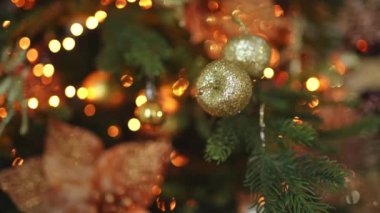Mutlu Noeller Noel 'ler. Altın süsleme topu ve süslenmiş klasik Noel ağacının üzerindeki çelenk ışıkları. Altın süslemeli Noel ağacı. Evde Noel arifesi