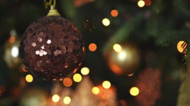 Mutlu Noeller Noel 'ler. Altın süsleme topu ve süslenmiş klasik Noel ağacının üzerindeki çelenk ışıkları. Kahverengi süslemeli Noel ağacı. Evde Noel arifesi