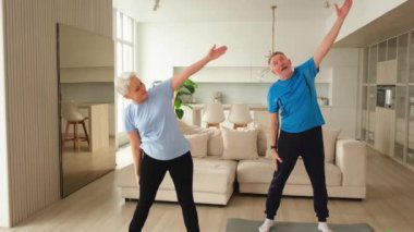 Fitness antrenmanı. Yetişkin, sağlıklı, yaşlı bir çift evde yoga minderinde spor yapıyor. Orta yaşlı koca karısı antrenman yapıyor. Sağlık hizmetleri sağlıklı yaşam tarzı
