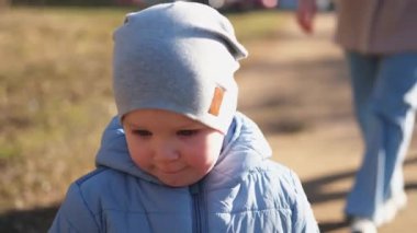 Dışarıda mutlu bir aile. Anne çocuk parkta yürüyor. Anne dışarıda oğluyla oynuyor. Kadın küçük erkek bebek doğada dinleniyor. Küçük çocuk ve bebek bakıcısı birlikte eğleniyorlar.