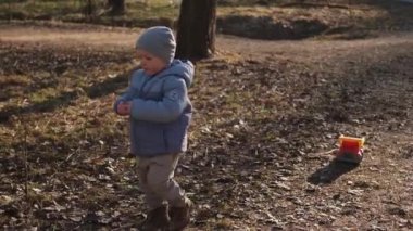 Dışarıda mutlu bir aile. Anne çocuk parkta yürüyor. Anne dışarıda oğluyla oynuyor. Kadın küçük erkek bebek doğada dinleniyor. Küçük çocuk ve bebek bakıcısı birlikte eğleniyorlar.