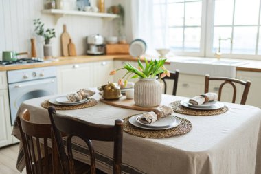 İskandinav klasiği beyaz ve ahşap çiçekli minimalist mutfak. Modern beyaz mutfak, çağdaş tarz iç tasarım. Boş parlak beyaz iç mekan, mutfak minimumu