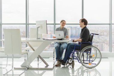 İş arkadaşları, kadın sandalyeye oturanlar, engelli çalışanlar için. Şirket kurma ekibi birlikte çalışıyor. Şirket profesyonel takımı proje fikirlerini tartışıyor