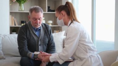 Doktor muayenehanesinde ya da evde tansiyonunu ölçen yaşlı bayan doktor. Yaşlı hasta ve doktorun hastane odasında muayeneleri var. Tıbbi sağlık hizmetleri sağlık kontrolü. Doktoru ziyaret et.