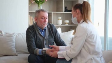 Doktor muayenehanesinde ya da evde tansiyonunu ölçen yaşlı bayan doktor. Yaşlı hasta ve doktorun hastane odasında muayeneleri var. Tıbbi sağlık hizmetleri sağlık kontrolü. Doktoru ziyaret et.