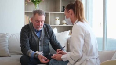 Doktor muayenehanesinde ya da evde tansiyonunu ölçen yaşlı bayan doktor. Yaşlı hasta ve doktorun hastane odasında muayeneleri var. Tıbbi sağlık hizmetleri sağlık kontrolü. Doktoru ziyaret et.