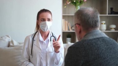 Doktor muayenehanesinde ya da evde yaşlı bir adamı muayene eden kadın doktor. Yaşlı hasta ve doktorun hastane odasında muayeneleri var. Tıbbi sağlık hizmetleri sağlık kontrolü. Doktoru ziyaret et.