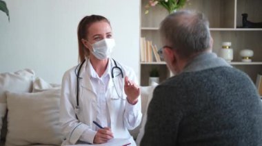 Doktor muayenehanesinde ya da evde yaşlı bir adamı muayene eden kadın doktor. Yaşlı hasta ve doktorun hastane odasında muayeneleri var. Tıbbi sağlık hizmetleri sağlık kontrolü. Doktoru ziyaret et.