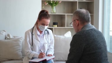 Doktor muayenehanesinde ya da evde yaşlı bir adamı muayene eden kadın doktor. Yaşlı hasta ve doktorun hastane odasında muayeneleri var. Tıbbi sağlık hizmetleri sağlık kontrolü. Doktoru ziyaret et.