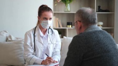 Doktor muayenehanesinde ya da evde yaşlı bir adamı muayene eden kadın doktor. Yaşlı hasta ve doktorun hastane odasında muayeneleri var. Tıbbi sağlık hizmetleri sağlık kontrolü. Doktoru ziyaret et.