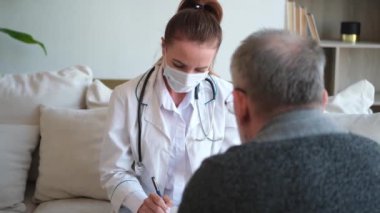 Doktor muayenehanesinde ya da evde yaşlı bir adamı muayene eden kadın doktor. Yaşlı hasta ve doktorun hastane odasında muayeneleri var. Tıbbi sağlık hizmetleri sağlık kontrolü. Doktoru ziyaret et.