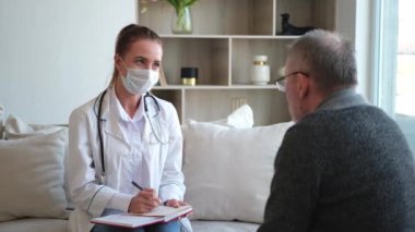 Doktor muayenehanesinde ya da evde yaşlı bir adamı muayene eden kadın doktor. Yaşlı hasta ve doktorun hastane odasında muayeneleri var. Tıbbi sağlık hizmetleri sağlık kontrolü. Doktoru ziyaret et.