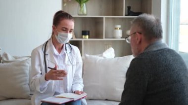 Doktor muayenehanesinde ya da evde yaşlı bir adamı muayene eden kadın doktor. Yaşlı hasta ve doktorun hastane odasında muayeneleri var. Tıbbi sağlık hizmetleri sağlık kontrolü. Doktoru ziyaret et.