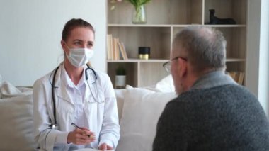 Doktor muayenehanesinde ya da evde yaşlı bir adamı muayene eden kadın doktor. Yaşlı hasta ve doktorun hastane odasında muayeneleri var. Tıbbi sağlık hizmetleri sağlık kontrolü. Doktoru ziyaret et.