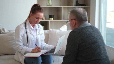 Doktor muayenehanesinde ya da evde yaşlı bir adamı muayene eden kadın doktor. Yaşlı hasta ve doktorun hastane odasında muayeneleri var. Tıbbi sağlık hizmetleri sağlık kontrolü. Doktoru ziyaret et.