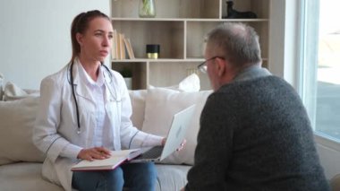 Doktor muayenehanesinde ya da evde yaşlı bir adamı muayene eden kadın doktor. Yaşlı hasta ve doktorun hastane odasında muayeneleri var. Tıbbi sağlık hizmetleri sağlık kontrolü. Doktoru ziyaret et.