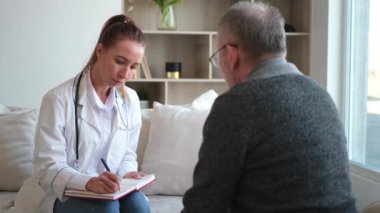Doktor muayenehanesinde ya da evde yaşlı bir adamı muayene eden kadın doktor. Yaşlı hasta ve doktorun hastane odasında muayeneleri var. Tıbbi sağlık hizmetleri sağlık kontrolü. Doktoru ziyaret et.