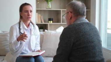 Doktor muayenehanesinde ya da evde yaşlı bir adamı muayene eden kadın doktor. Yaşlı hasta ve doktorun hastane odasında muayeneleri var. Tıbbi sağlık hizmetleri sağlık kontrolü. Doktoru ziyaret et.