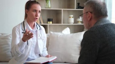 Doktor muayenehanesinde ya da evde yaşlı bir adamı muayene eden kadın doktor. Yaşlı hasta ve doktorun hastane odasında muayeneleri var. Tıbbi sağlık hizmetleri sağlık kontrolü. Doktoru ziyaret et.