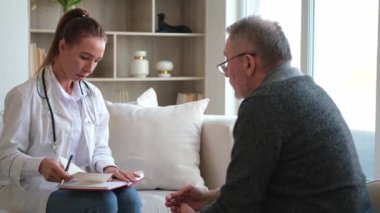 Doktor muayenehanesinde ya da evde yaşlı bir adamı muayene eden kadın doktor. Yaşlı hasta ve doktorun hastane odasında muayeneleri var. Tıbbi sağlık hizmetleri sağlık kontrolü. Doktoru ziyaret et.