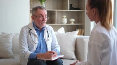 Kıdemli doktor, genç bayanı muayenehanede ya da evde muayene ediyor. Kız hasta ve doktorun hastane odasında muayenesi var. Tıbbi sağlık hizmetleri sağlık kontrolü. Doktoru ziyaret et.