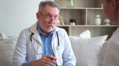 Kıdemli doktor, genç bayanı muayenehanede ya da evde muayene ediyor. Kız hasta ve doktorun hastane odasında muayenesi var. Tıbbi sağlık hizmetleri sağlık kontrolü. Doktoru ziyaret et.