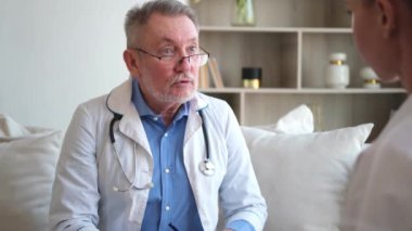 Kıdemli doktor, genç bayanı muayenehanede ya da evde muayene ediyor. Kız hasta ve doktorun hastane odasında muayenesi var. Tıbbi sağlık hizmetleri sağlık kontrolü. Doktoru ziyaret et.