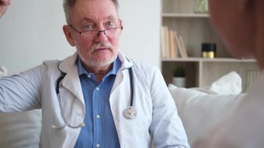 Kıdemli doktor, genç bayanı muayenehanede ya da evde muayene ediyor. Kız hasta ve doktorun hastane odasında muayenesi var. Tıbbi sağlık hizmetleri sağlık kontrolü. Doktoru ziyaret et.