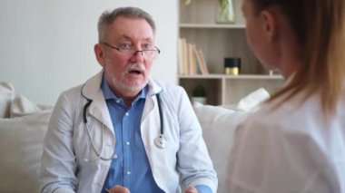 Kıdemli doktor, genç bayanı muayenehanede ya da evde muayene ediyor. Kız hasta ve doktorun hastane odasında muayenesi var. Tıbbi sağlık hizmetleri sağlık kontrolü. Doktoru ziyaret et.