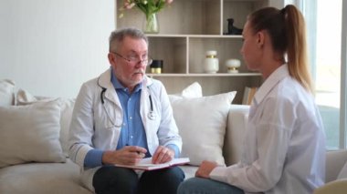 Kıdemli doktor, genç bayanı muayenehanede ya da evde muayene ediyor. Kız hasta ve doktorun hastane odasında muayenesi var. Tıbbi sağlık hizmetleri sağlık kontrolü. Doktoru ziyaret et.