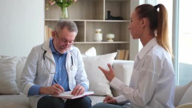 Kıdemli doktor, genç bayanı muayenehanede ya da evde muayene ediyor. Kız hasta ve doktorun hastane odasında muayenesi var. Tıbbi sağlık hizmetleri sağlık kontrolü. Doktoru ziyaret et.