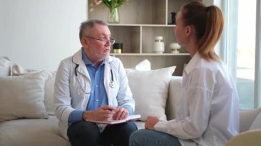 Kıdemli doktor, genç bayanı muayenehanede ya da evde muayene ediyor. Kız hasta ve doktorun hastane odasında muayenesi var. Tıbbi sağlık hizmetleri sağlık kontrolü. Doktoru ziyaret et.