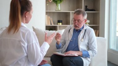 Kıdemli doktor, genç bayanı muayenehanede ya da evde muayene ediyor. Kız hasta ve doktorun hastane odasında muayenesi var. Tıbbi sağlık hizmetleri sağlık kontrolü. Doktoru ziyaret et.