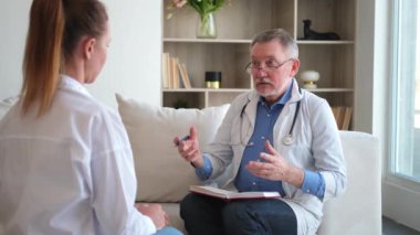 Kıdemli doktor, genç bayanı muayenehanede ya da evde muayene ediyor. Kız hasta ve doktorun hastane odasında muayenesi var. Tıbbi sağlık hizmetleri sağlık kontrolü. Doktoru ziyaret et.