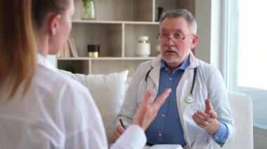 Kıdemli doktor, genç bayanı muayenehanede ya da evde muayene ediyor. Kız hasta ve doktorun hastane odasında muayenesi var. Tıbbi sağlık hizmetleri sağlık kontrolü. Doktoru ziyaret et.