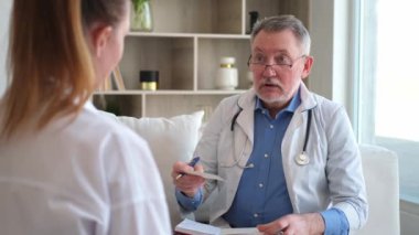 Kıdemli doktor, genç bayanı muayenehanede ya da evde muayene ediyor. Kız hasta ve doktorun hastane odasında muayenesi var. Tıbbi sağlık hizmetleri sağlık kontrolü. Doktoru ziyaret et.