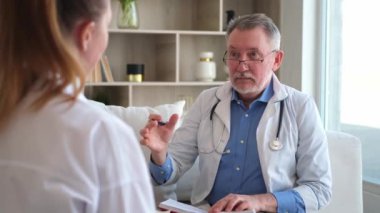 Kıdemli doktor, genç bayanı muayenehanede ya da evde muayene ediyor. Kız hasta ve doktorun hastane odasında muayenesi var. Tıbbi sağlık hizmetleri sağlık kontrolü. Doktoru ziyaret et.