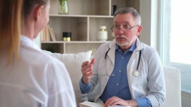 Kıdemli doktor, genç bayanı muayenehanede ya da evde muayene ediyor. Kız hasta ve doktorun hastane odasında muayenesi var. Tıbbi sağlık hizmetleri sağlık kontrolü. Doktoru ziyaret et.