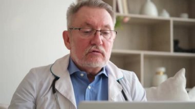 Bilgisayardan konuşan kıdemli doktor hastaya danışmak istiyor. Profesyonel yetişkin sağlık uzmanı hastayı internetten muayene ediyor. Tıbbi sağlık hizmetleri sağlık kontrolü